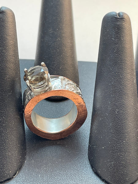 A very thick band of textured reticulated silver accented with a brown smoky quartz stone. The ring also has copper and silver. It is a hollow ring.  Size 8.