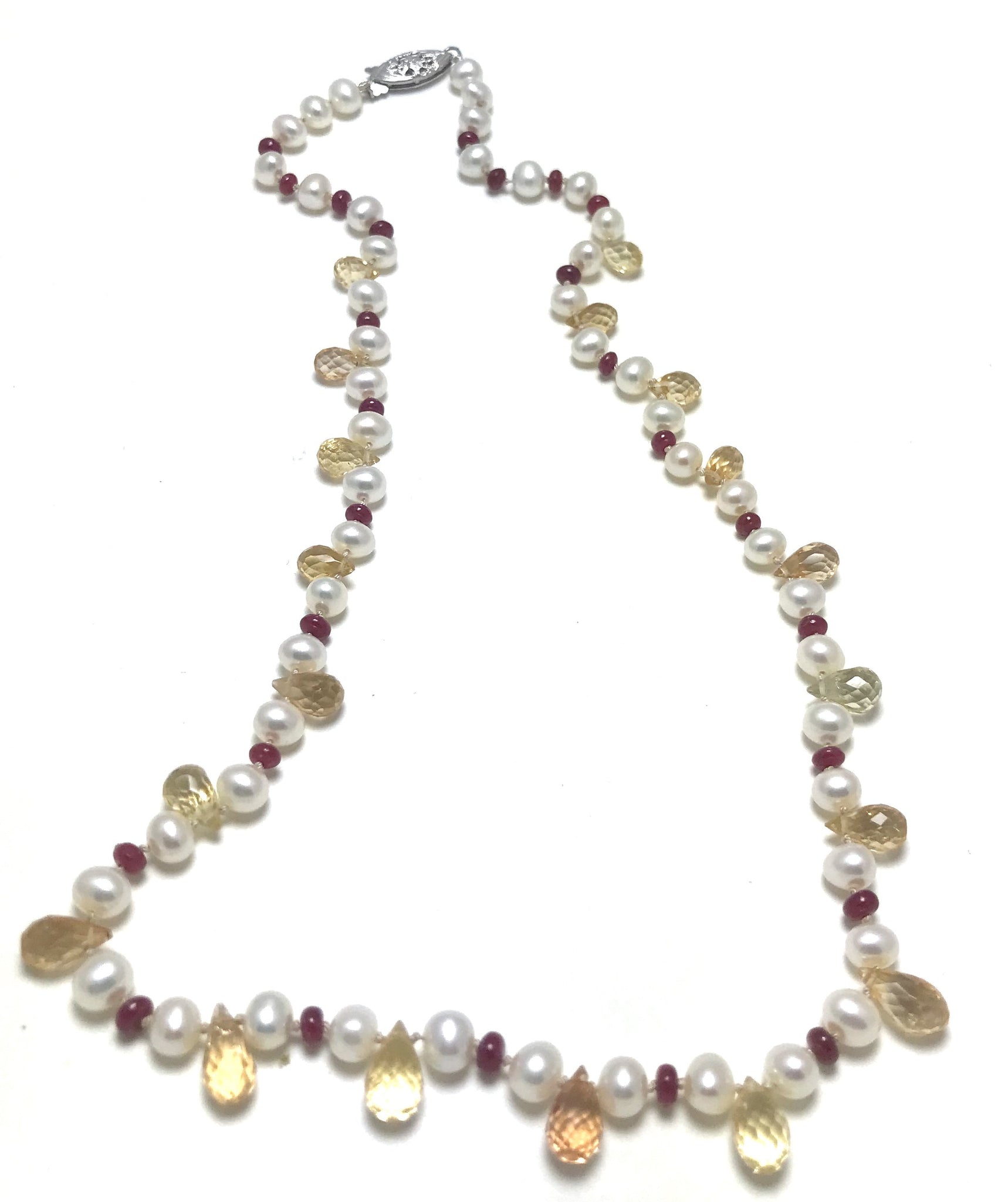 A pearl knotted piece with white pearls, yellow topaz and red rubies.    